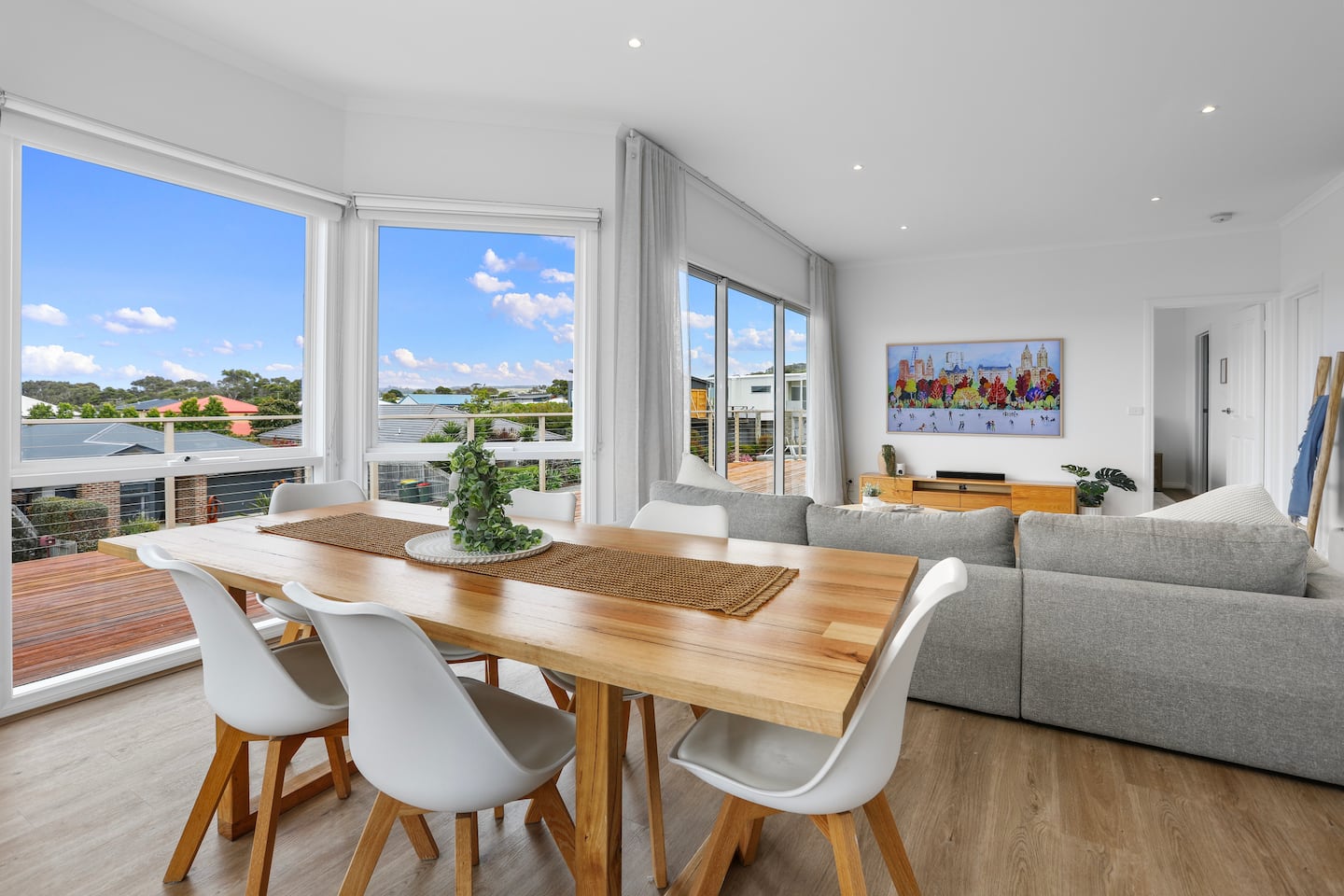 Sunlit dining and living area opening onto the beach house deck