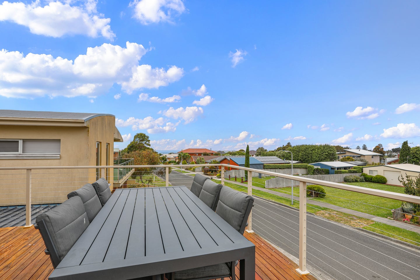 Outdoor dining table on the wrap-around deck beneath a blue sky
